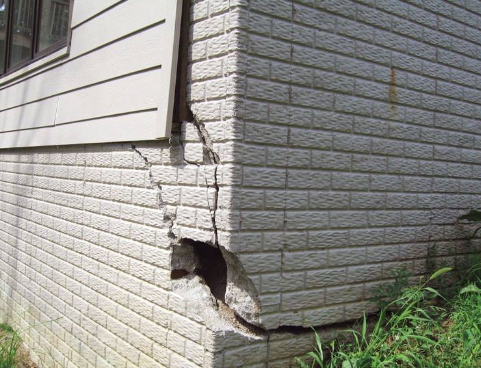 Photo of significant white brick damage to the corner of a house that is in need of foundation repair | DRY BASEMENT®