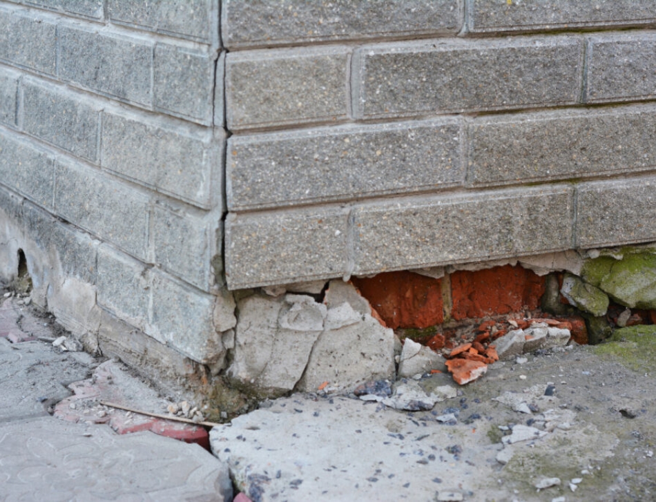 Photo of a cracked, damaged brick foundation.