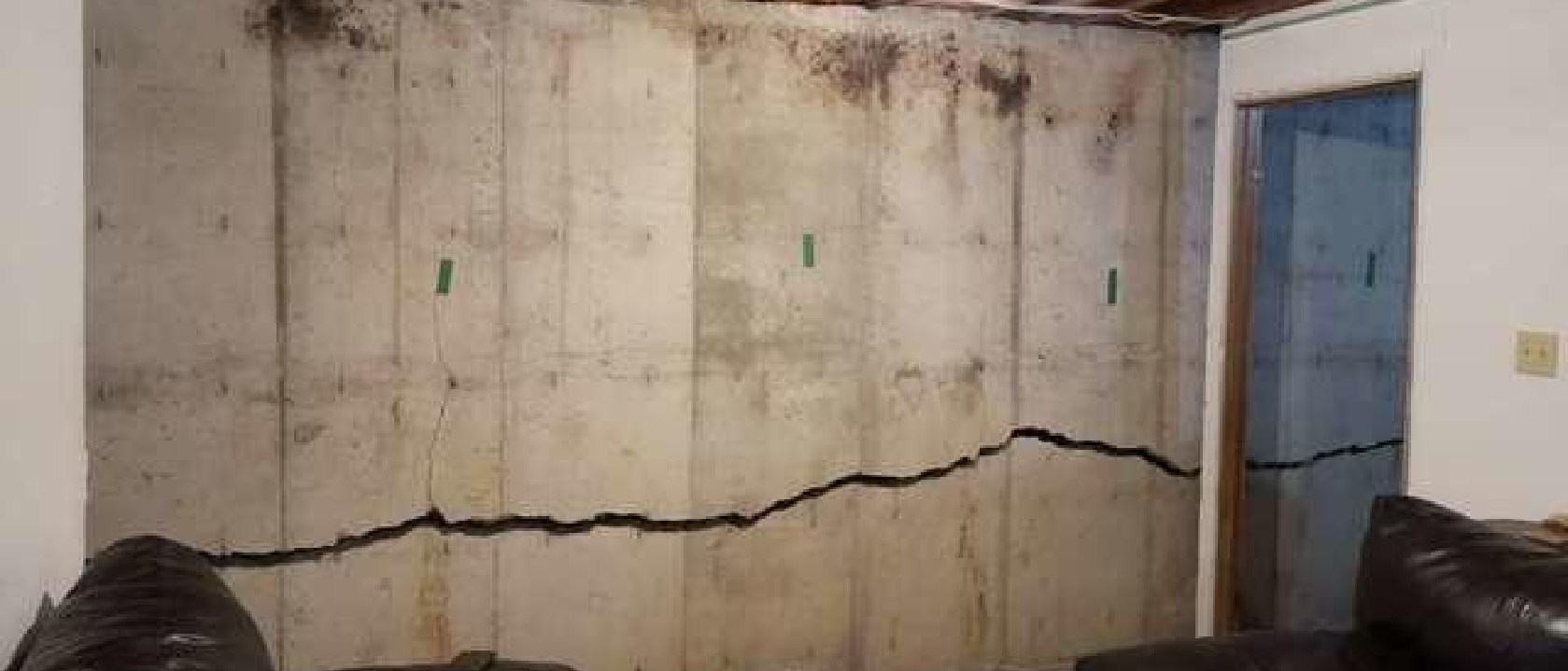 Photo of a wall showing a large crack across the lower portion.