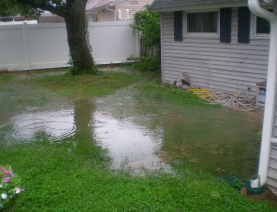Photo of a back yard with significant flooding due to poor drainage.